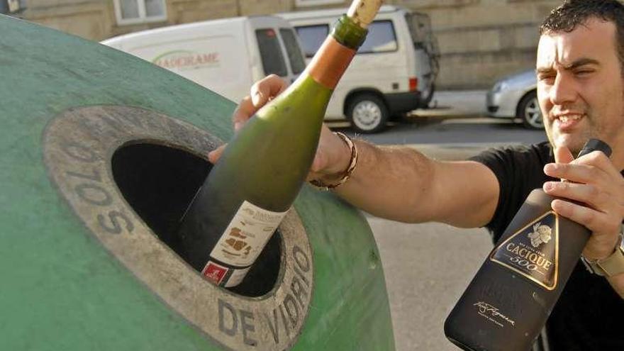 Un usuario recicla unas botellas de vidrio.