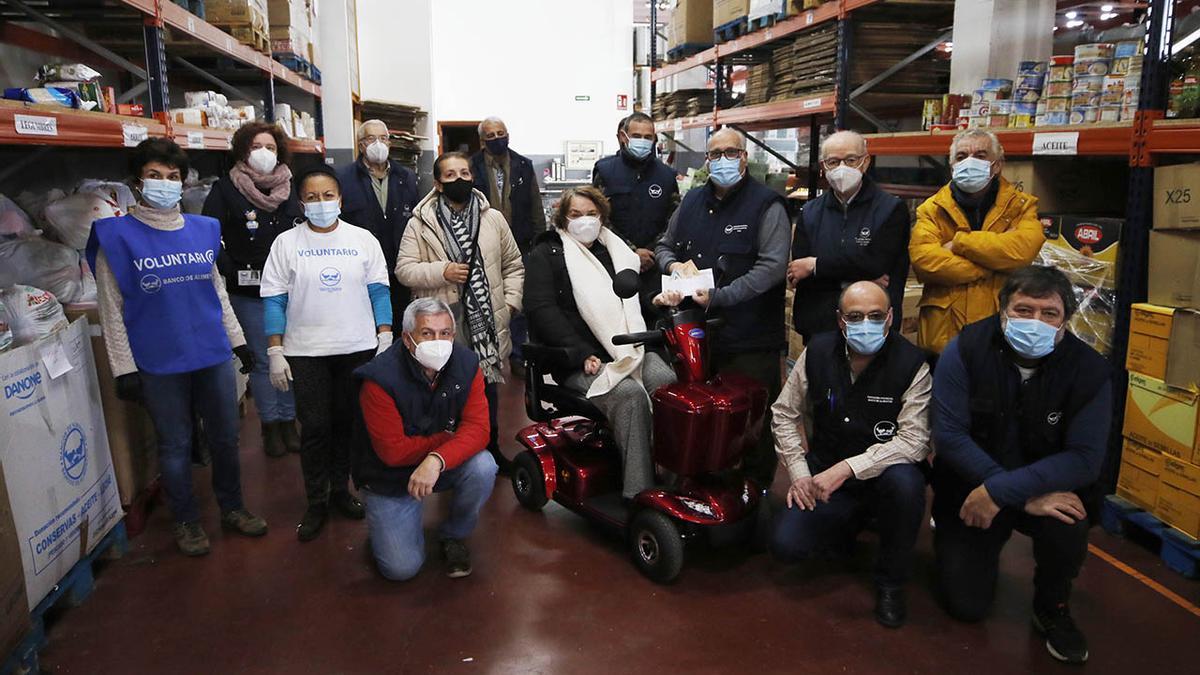 Ana Estévez, en su nueva moto adaptada, entrega ayer en el Banco de Alimentos de Vigo el dinero recaudado