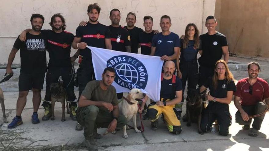 Foto de grupo de los 11 bomberos y los 3 perros buscapersonas de Bombers pel Món de València. | LEVANTE-EMV