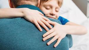 Un padre abrazando a su hijo.