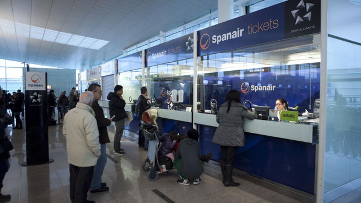 Pasajeros de Spanair, ante los mostradores de la compañía, el sábado, en el aeropuerto de El Prat.