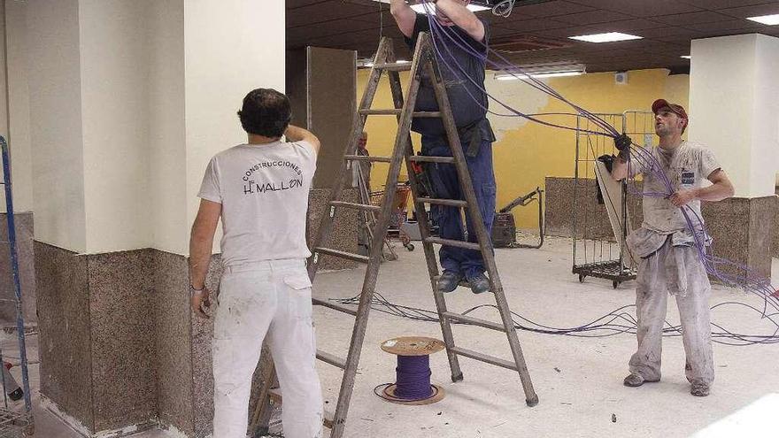 Trabajadores de la construcción realizando obras de reforma en un local. // Iñaki Osorio