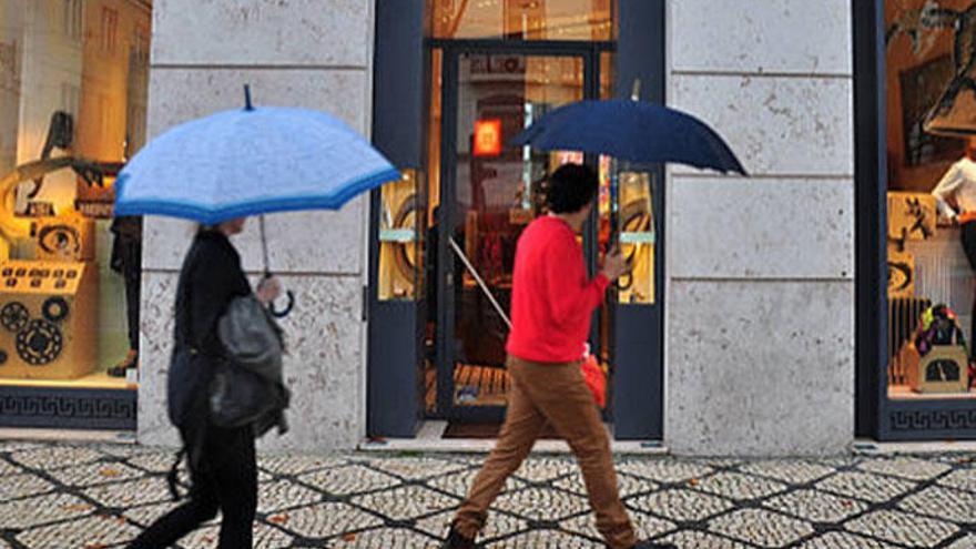 Dos personas pasan ante un escaparate.