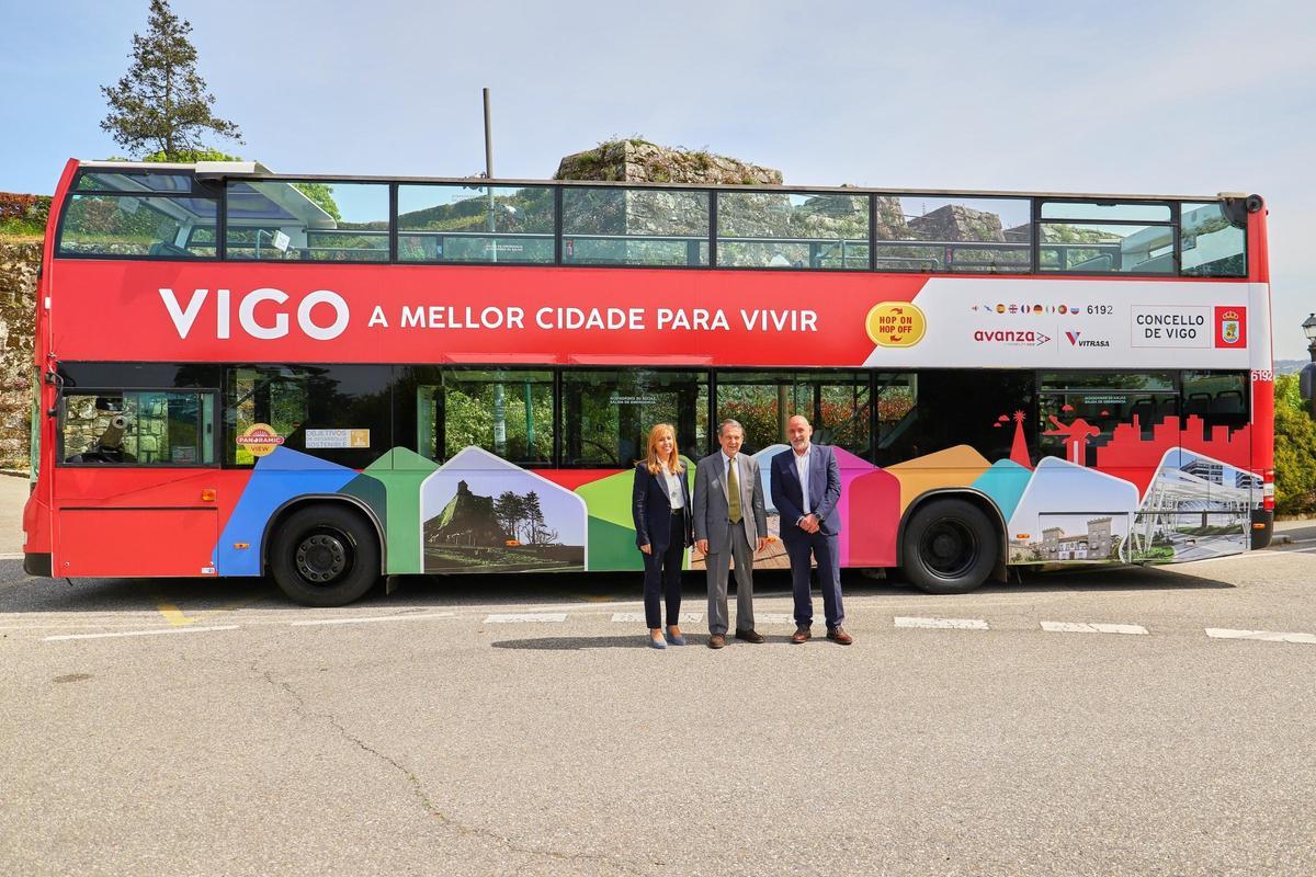 Caballero, en el centro, con Carlos González y María Lago. Detrás, el nuevo bus.