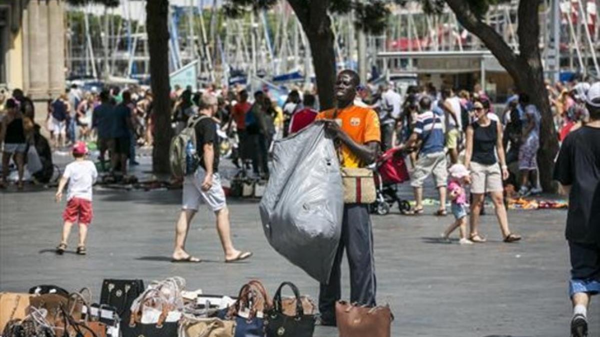 Un hombre expone su mercancía cerca del Maremágnum, en Barcelona.