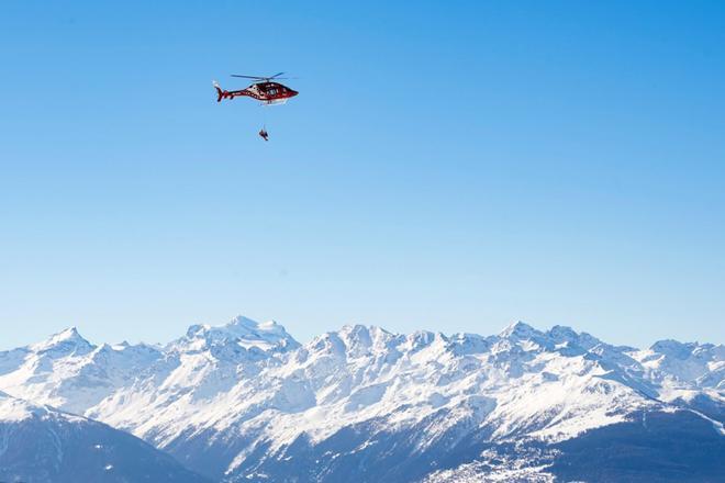 Un helicóptero de la compañía Air Zermatt traslada al esquiador Meike Pfister durante el entrenamiento del descenso femenino de la Copa del mundo de esquí alpino, este jueves en Crans-Montana, Suiza.