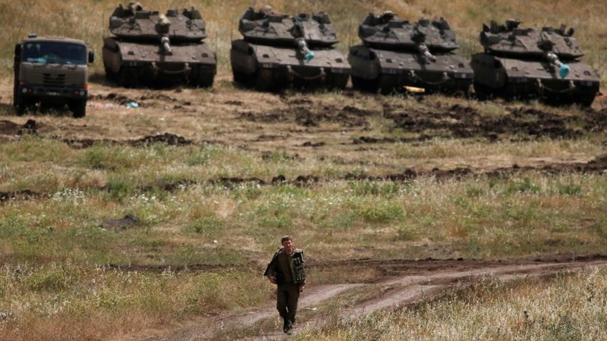 Un soldado israelí patrulla junto a tanques de su ejército en el territorio ocupado de los Altos del Golán.