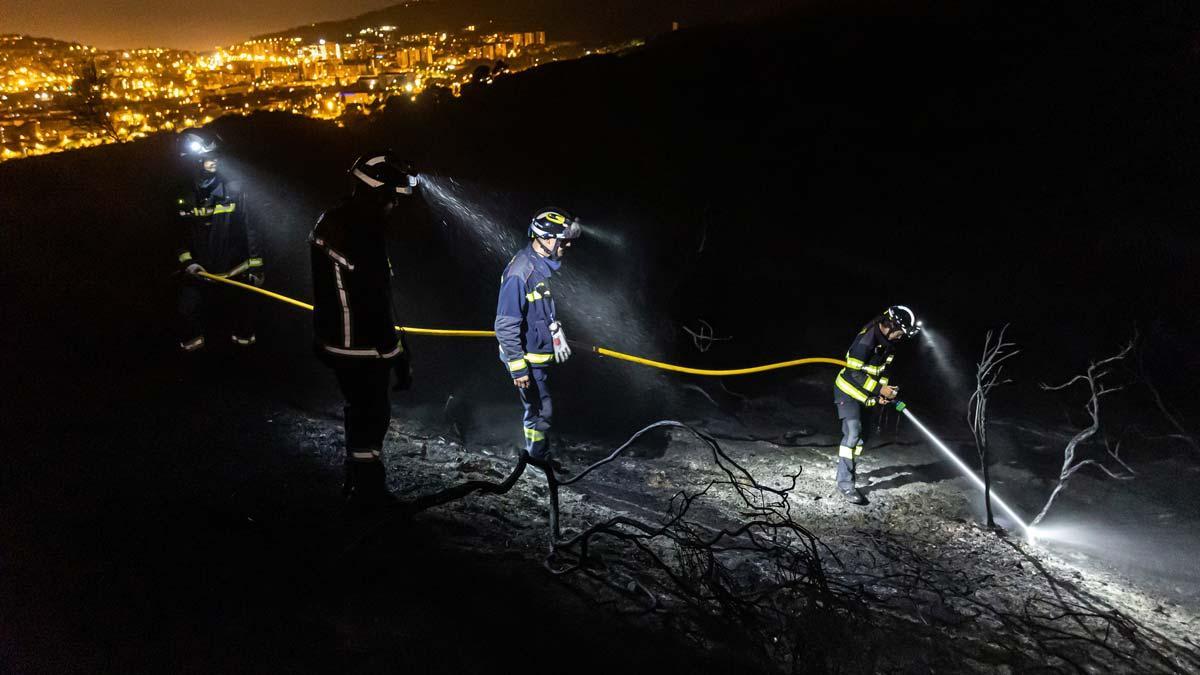 Los bomberos trabajan en la extinción del fuego de Collserola durante la noche