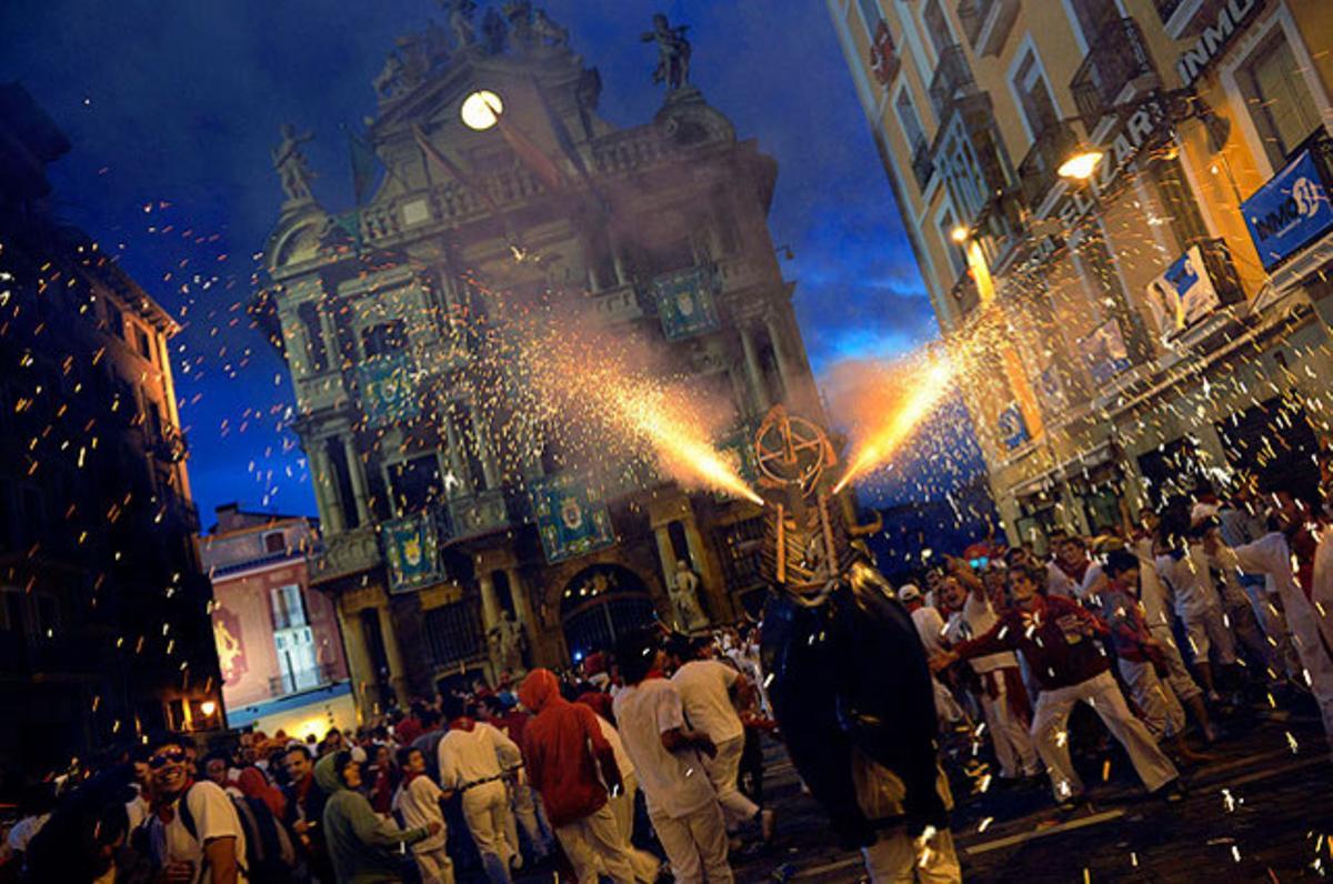 El ’toro de foc’, un home que porta una estructura de metall carregada amb focs artificials, durant les festes de Sant Fermí (Pamplona).