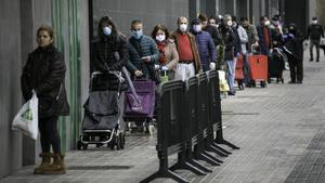 Colas de gente con mascarilla  en un supermercado de l’Hospitalet de Llobregat, esta mañana.