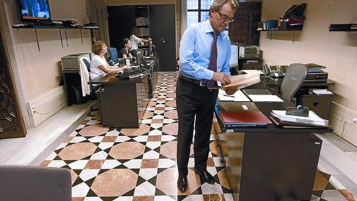 PREPARANDO EL DEBATE. El 'president' Mas, ayer, consultando unos documentos en la antesala de su despacho en el Palau de la Generalitat.