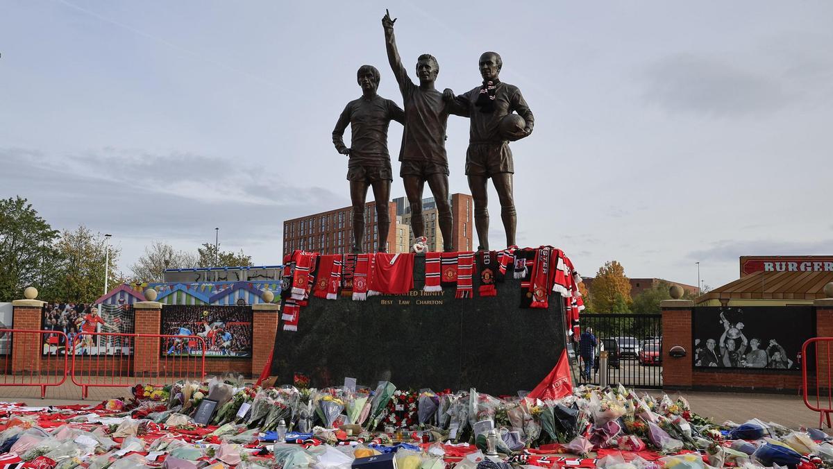 Denis Law, representado en el centro de una estatua junto a Old Trafford, con las figuras de Bobby Charlton y George Best.