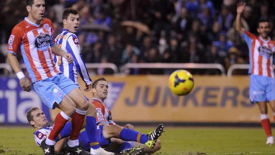 Álex, desde el suelo, y Luis miran el balón ante Pita en el último partido en Riazor.