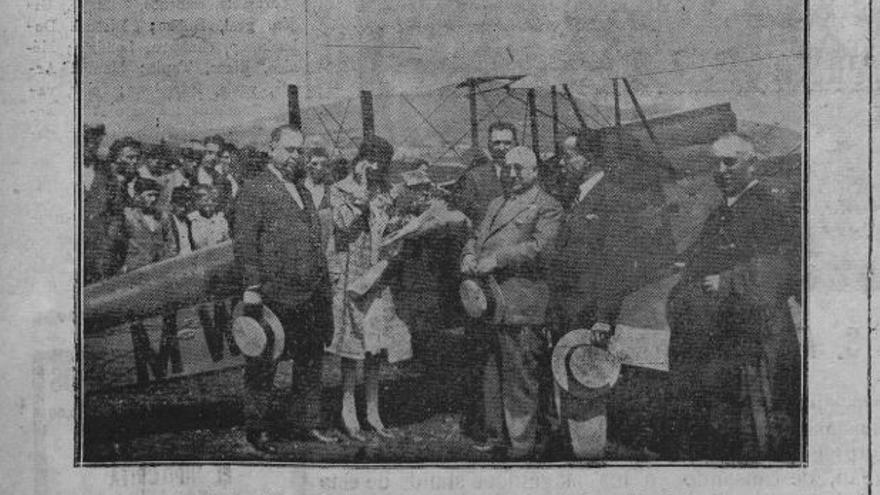 La aviadora, con un ramo de flores, en Llanera, ante el aparato y rodeada de autoridades que la recibieron el 21 de agosto de 1929.