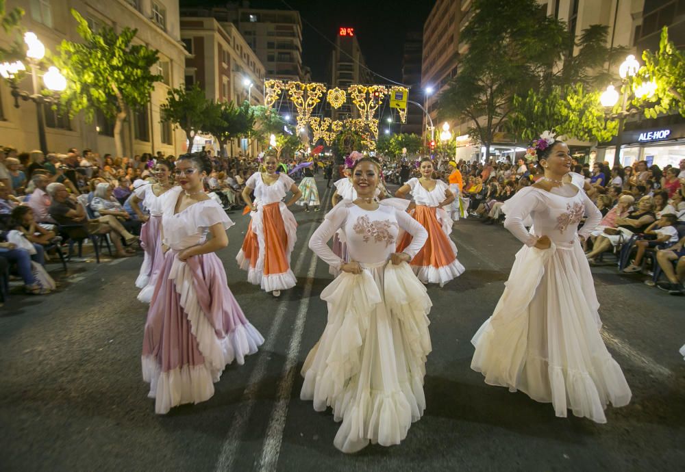 El desfile folclórico internacional de las Hogueras de Alicante llena de color las calles de la ciudad