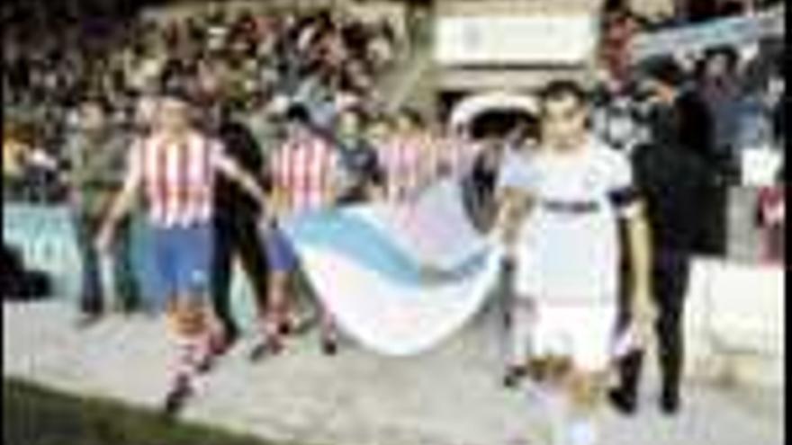Los jugadores de los dos equipos portan la bandera gallega antes de inciarse la final jugada ayer en el Anxo Carro. / El Progreso