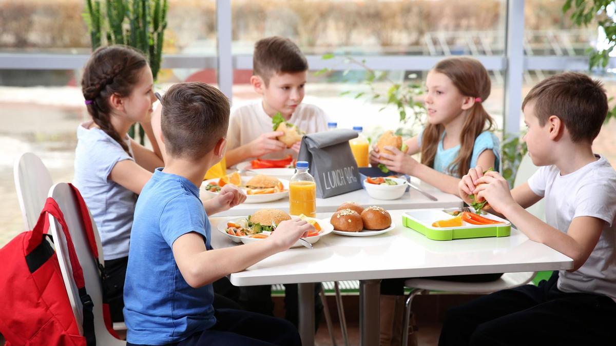 Un grupo de niños en un comedor escolar.