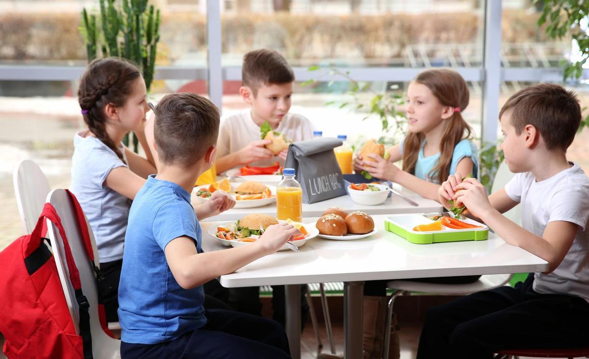 Un grupo de niños en un comedor escolar.