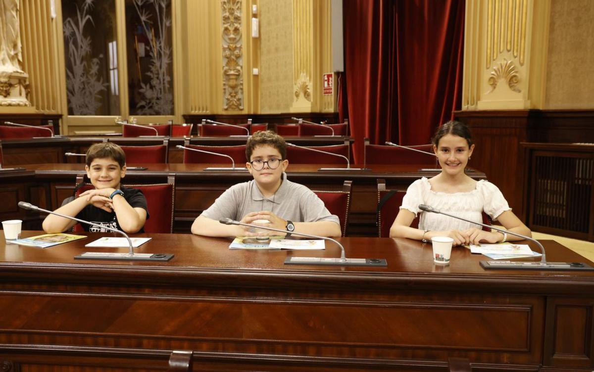 Tres niños posan felices en el interior del Parlament. | PARLAMENT