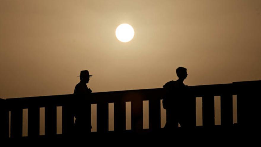 Dos personas pasean bajo el sol en plena ola de calor en Canarias.