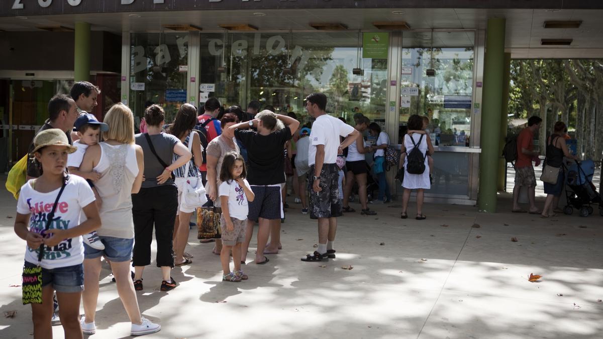 Un grupo de turistas esperan en la entrada del Zoo de Barcelona.