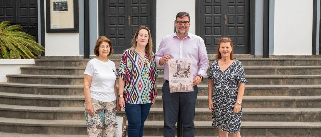 El alcalde de San Bartolomé muestra el cartel del espectáculo junto a representantes de la coral. | |