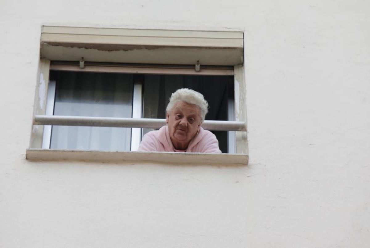 María Concepción Díaz se asoma a la ventana de su piso. | F. Rodríguez