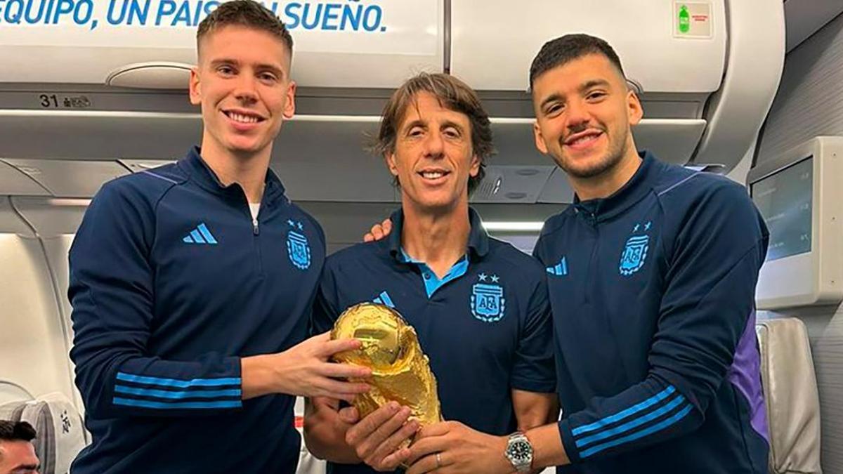 Juan Foyth y Gero Rulli posan con la Copa del Mundo tras lograr el título.