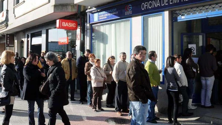 Un grupo de personas hace cola ante una oficina de empleo..