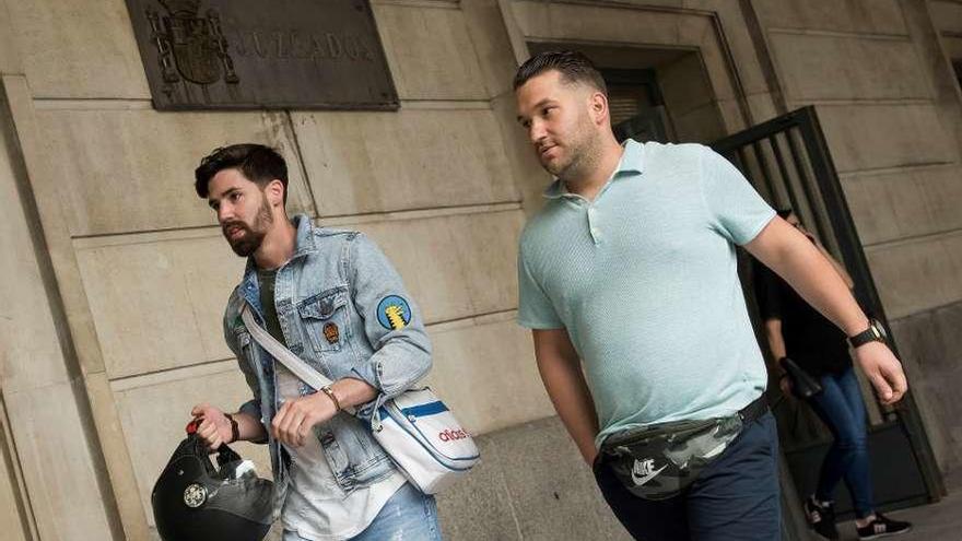 Jesús Escudero (izq.) y José Ángel Prenda, ayer, en el juzgado de guardia de Sevilla. // Efe