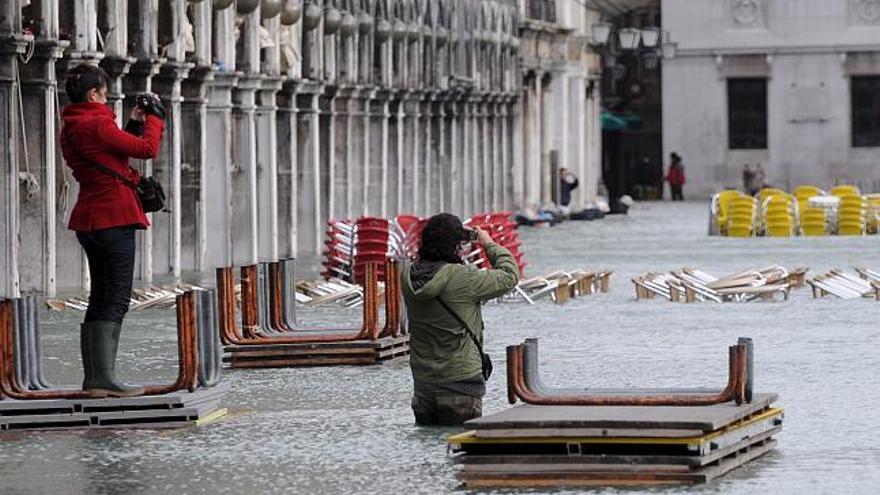 Turistas hacen fotos de la Plaza de San Marco inundada, Venecia, Italia, hoy lunes 1 de diciembre. La Plaza de San Marco se encuentra sumergida en casi un metro de agua después de que unas de las mayores olas registradas en la historia inundaran el centro de la ciudad.