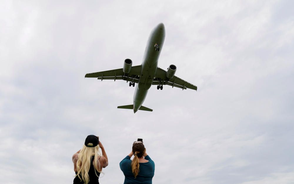 Flight attendants photograph a plane landing in ...