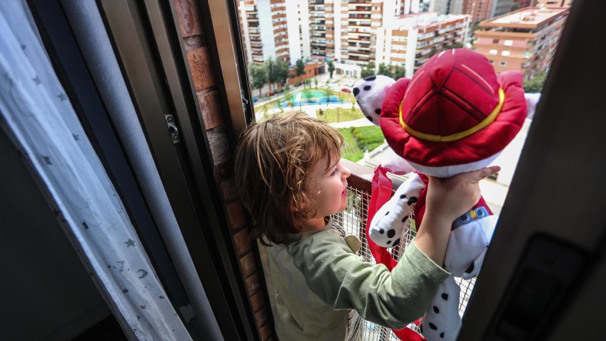 Un niño mira por la ventana de su casa horas antes de poder salir.