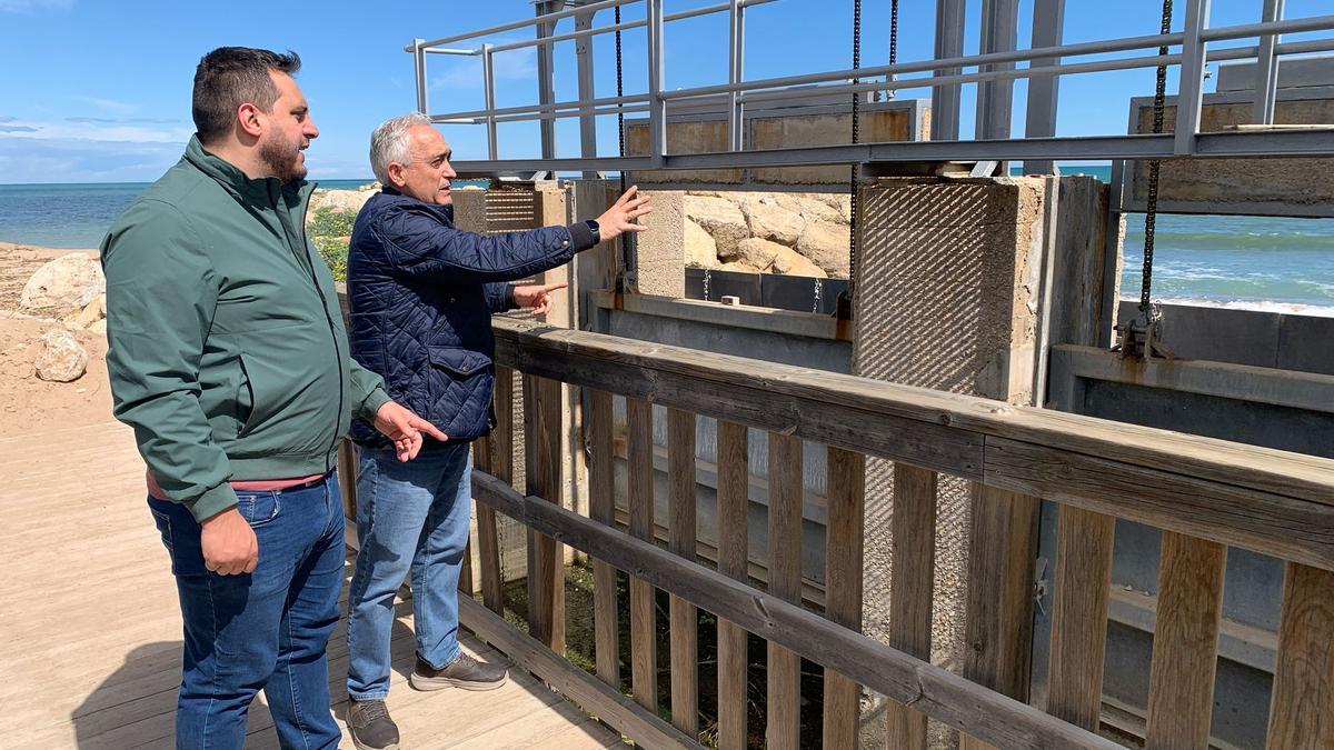 Los concejales Zeus Grau y José Enrique Cunyat, ante la compuerta del canal de la playa