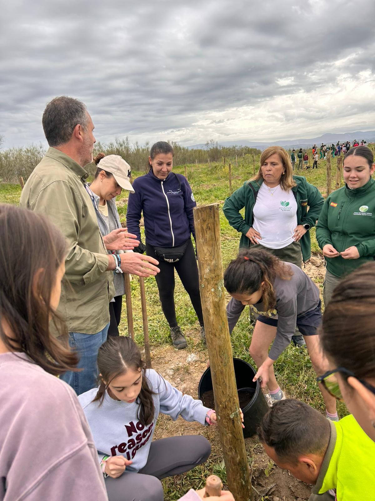 El alcalde conversa con participantes en las labores de reforestación.
