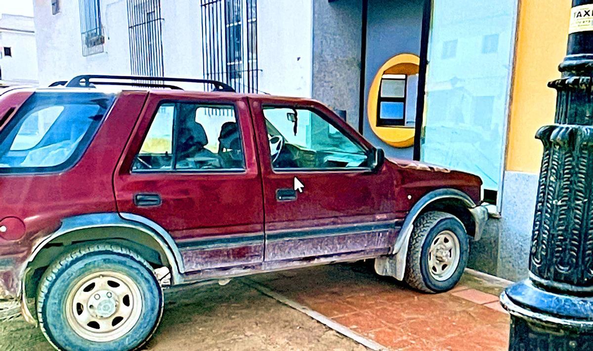 Imagen del coche estrellado contra la sucursal bancaria.