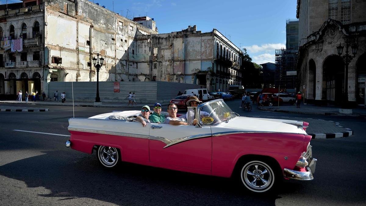 Unos turistas dan un paseo en un vehículo clásico utilizado como taxi en La Habana, el pasado 6 de mayo.
