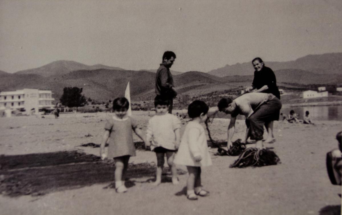 Una imatge antiga de Llançà amb pescadors i les xarxes a la platja.