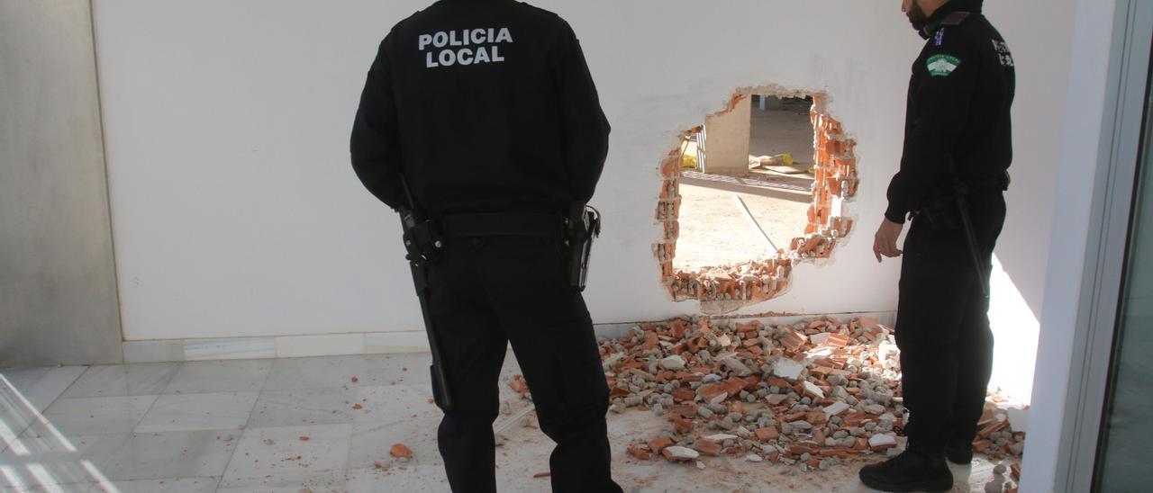 Dos agentes inspeccionan un butrón en una vivienda de Córdoba.