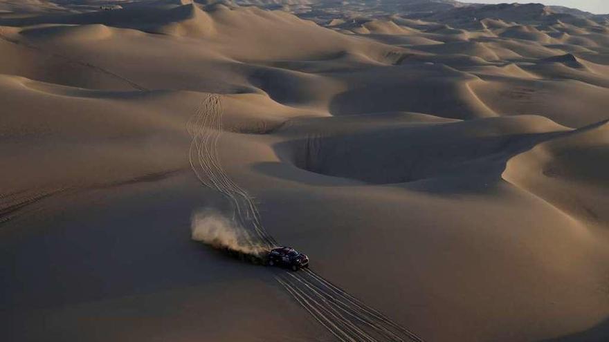 Uno de los coches atraviesa las dunas del desierto peruano. // Reuters