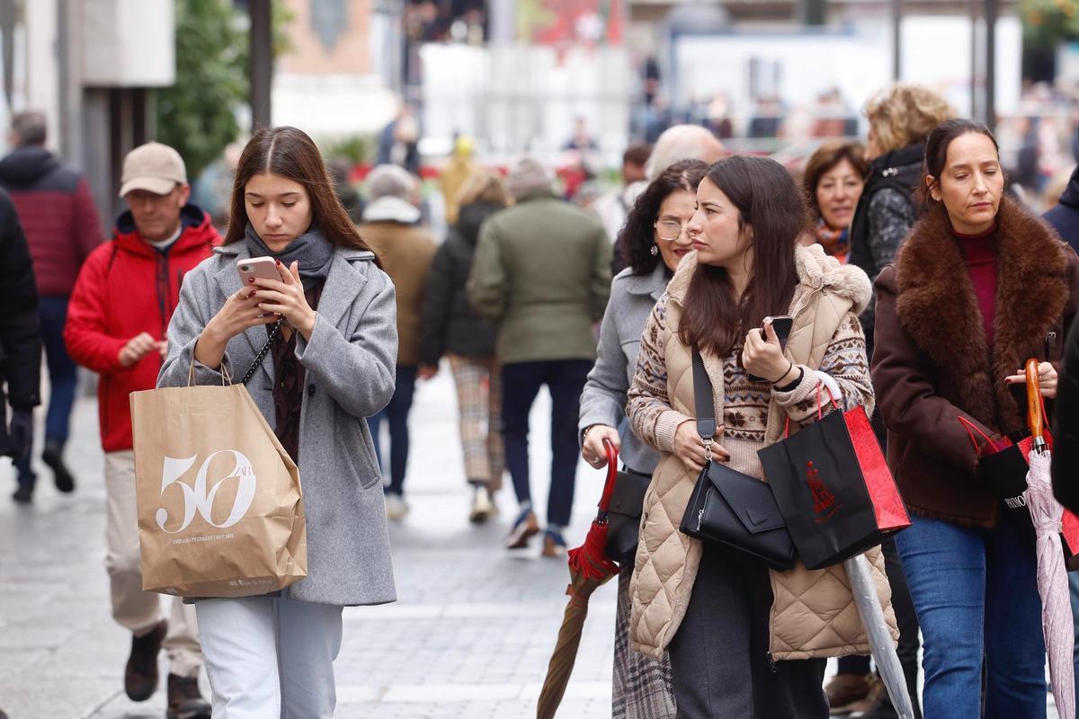 Varias mujeres pasean con bolsas en el centro de Córdoba.