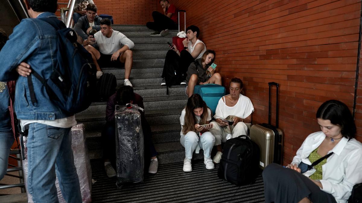Viajeros esperan en la estación de Atocha por los retrasos de trenes causados por la DANA.