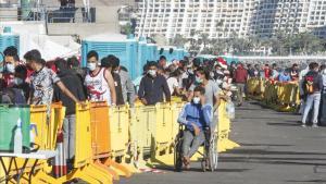 Varios inmigrantes hacen cola en el Muelle de Arguineguín en Gran Canaria  Canarias.