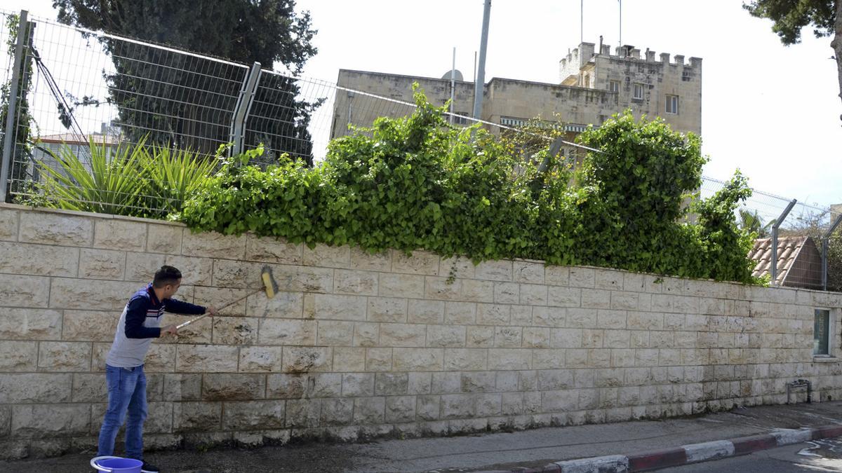 Un trabajador limpia el muro del Consulado General de España en Jerusalén, el 27 de marzo.