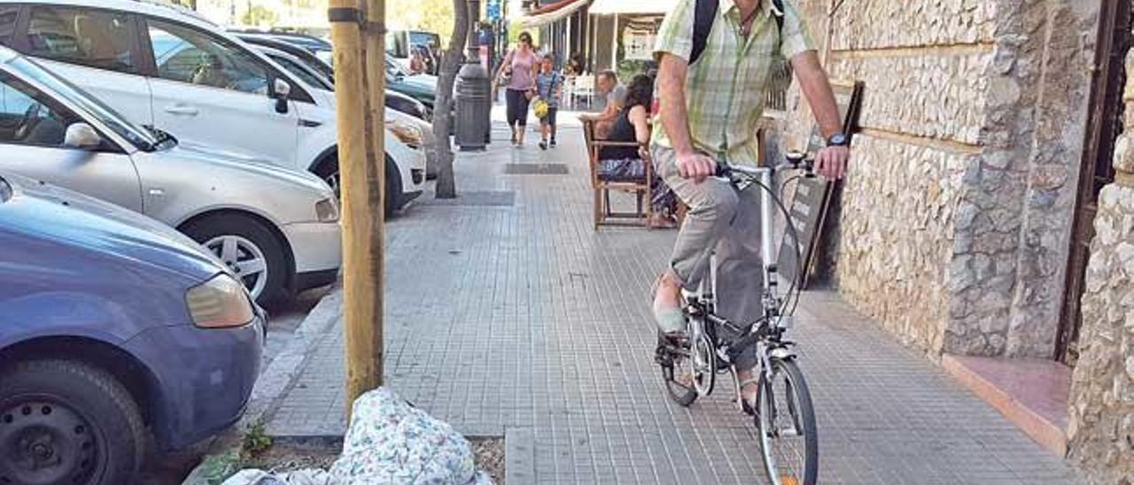 Un ciclista esquiva el colchón de la indigente en la calle Rubén Darío.