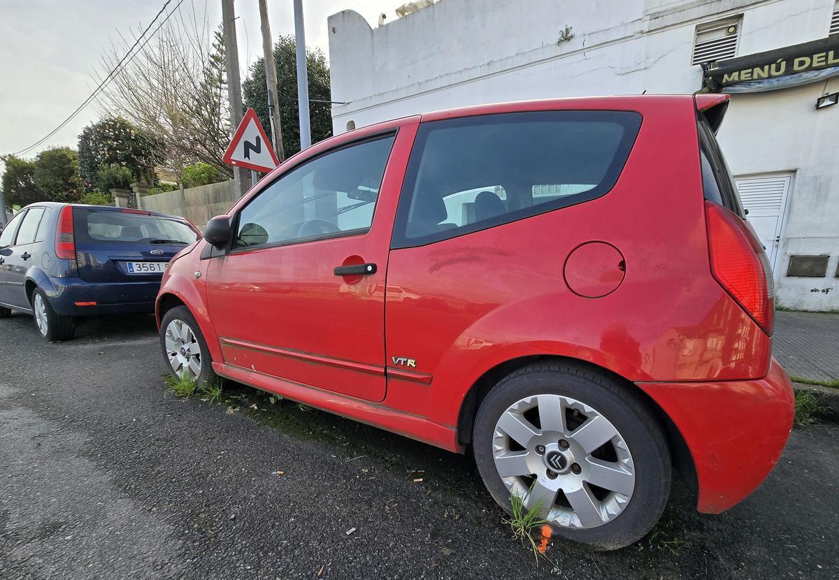 Coche abandonado en la calle Ángel de Lema y Marina, con una marca naranja en la rueda trasera.