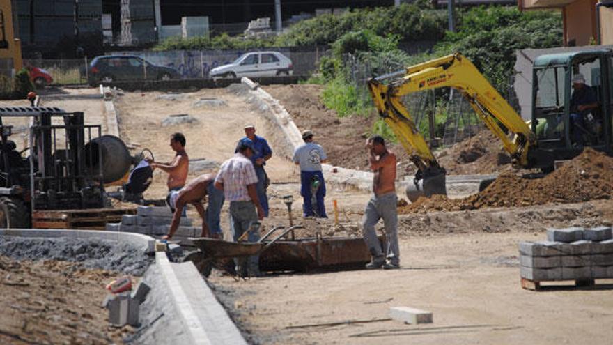 Los obreros del nuevo vial de As Lagoas, en Bueu, se enfrentan al calor y al polvo que levantan las máquinas.  // Carmen Giménez