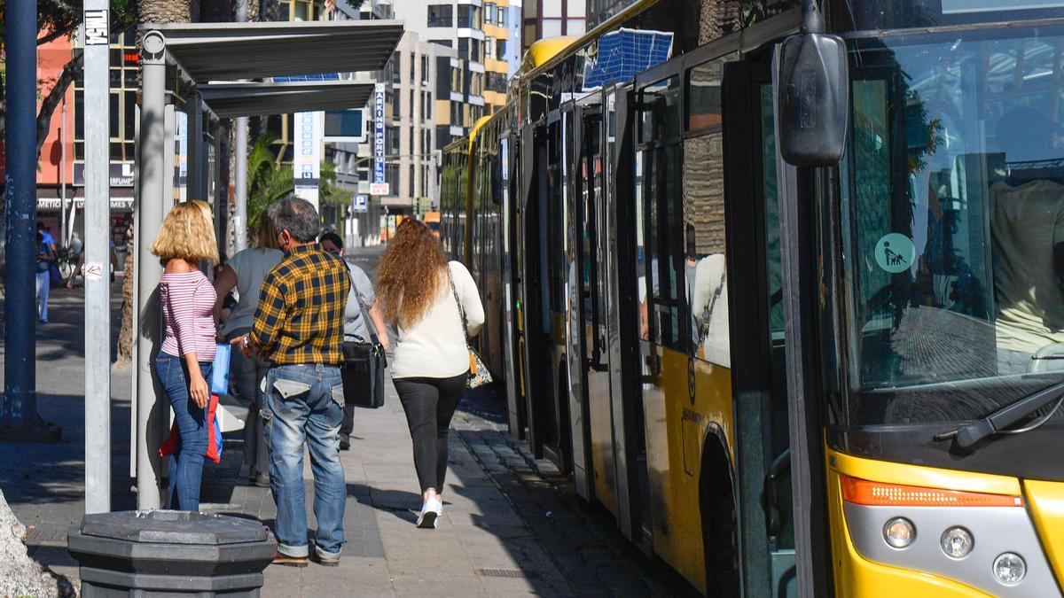 Pasajeros en una parada de guaguas.