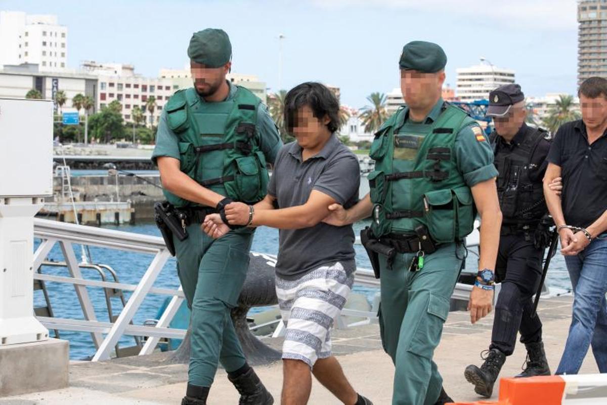 La Guardia Civil conduce detenidos a los tripulantes de un narcovelero serbio en el puerto de Las Palmas de Gran Canaria.