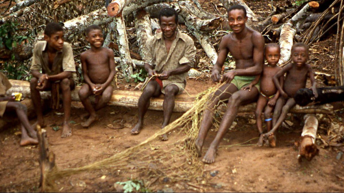 En una de las comunidades de cazadores y recolectores, un hombre muestra a un grupo de niños cómo tejer una red de caza.